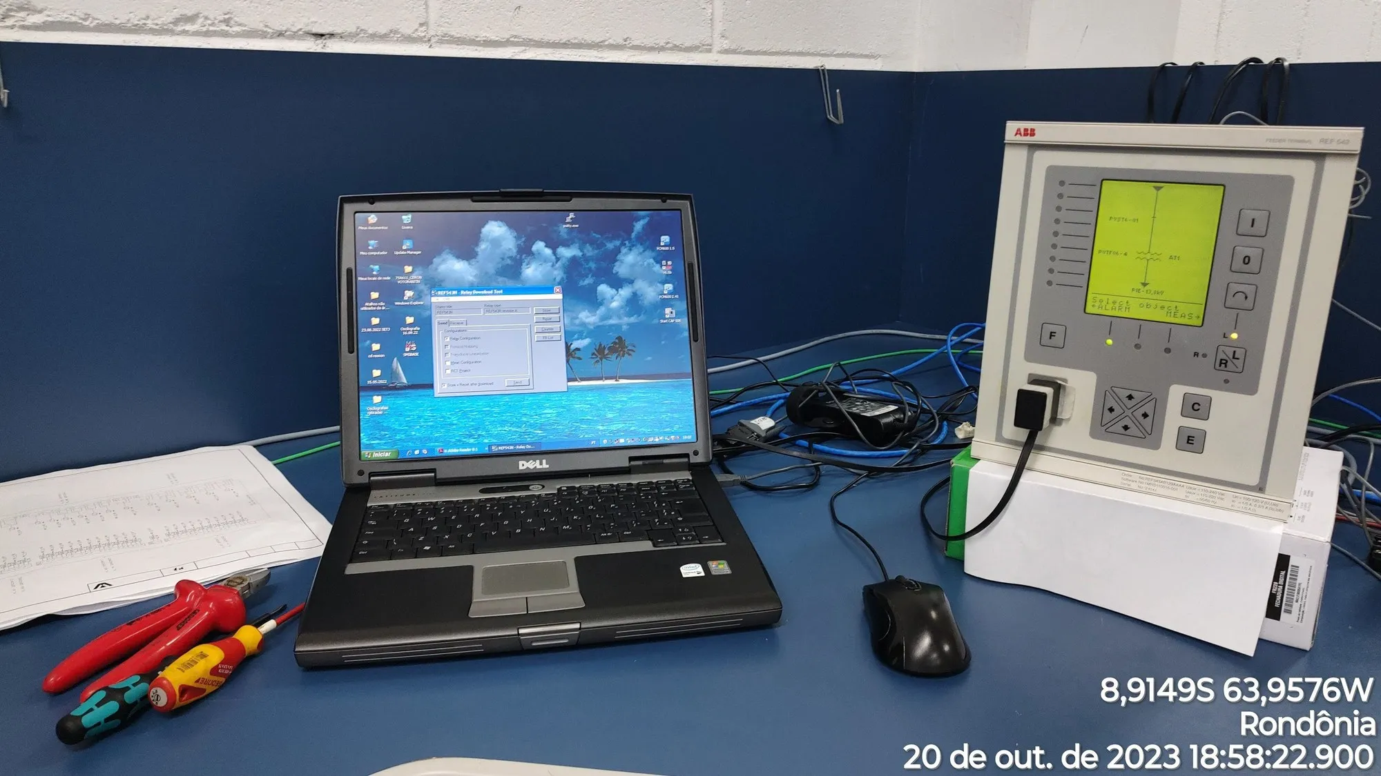 Notebook conectado a relé de proteção em bancada de ensaio